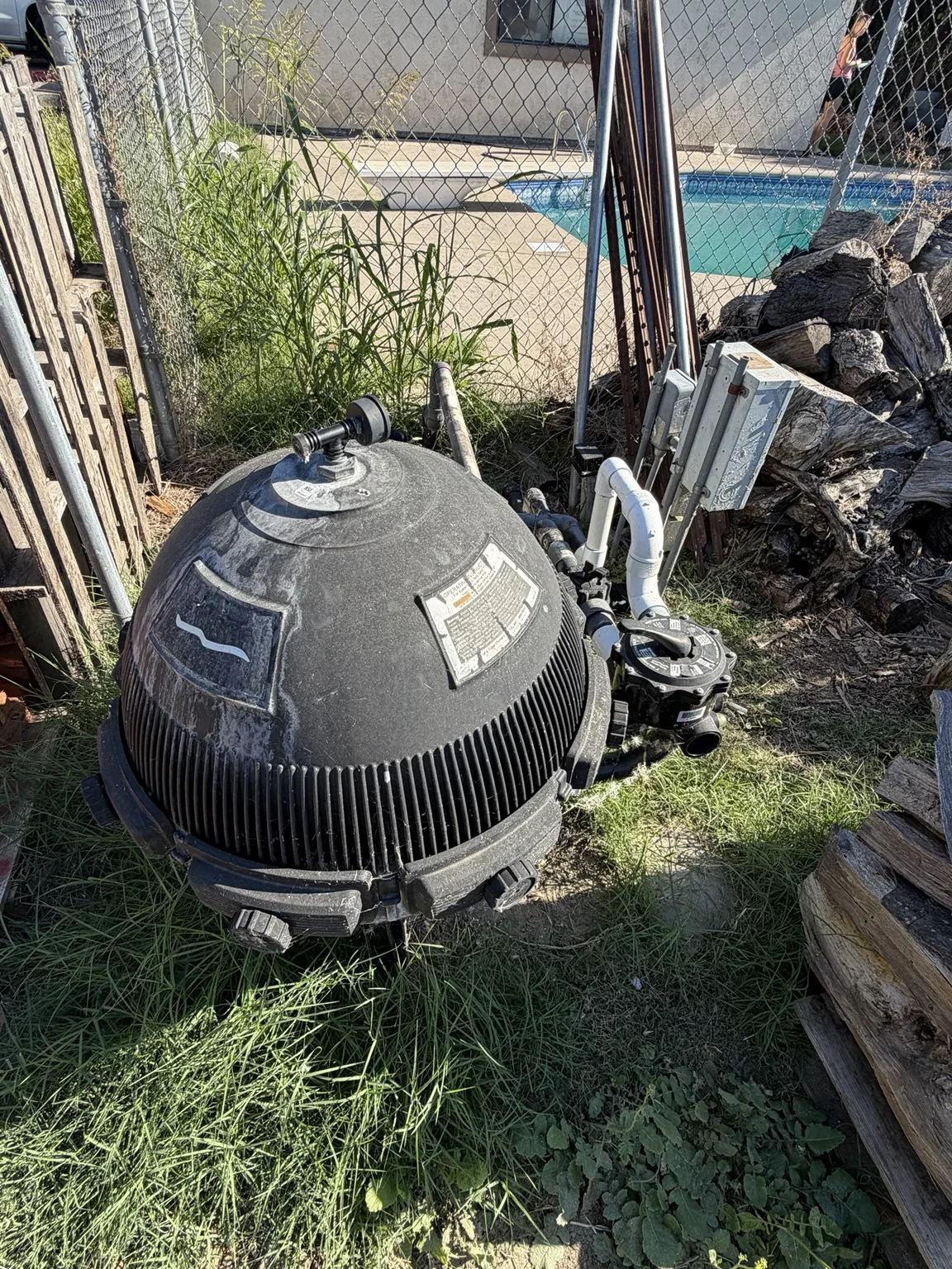 Older black pool filter tank before replacement